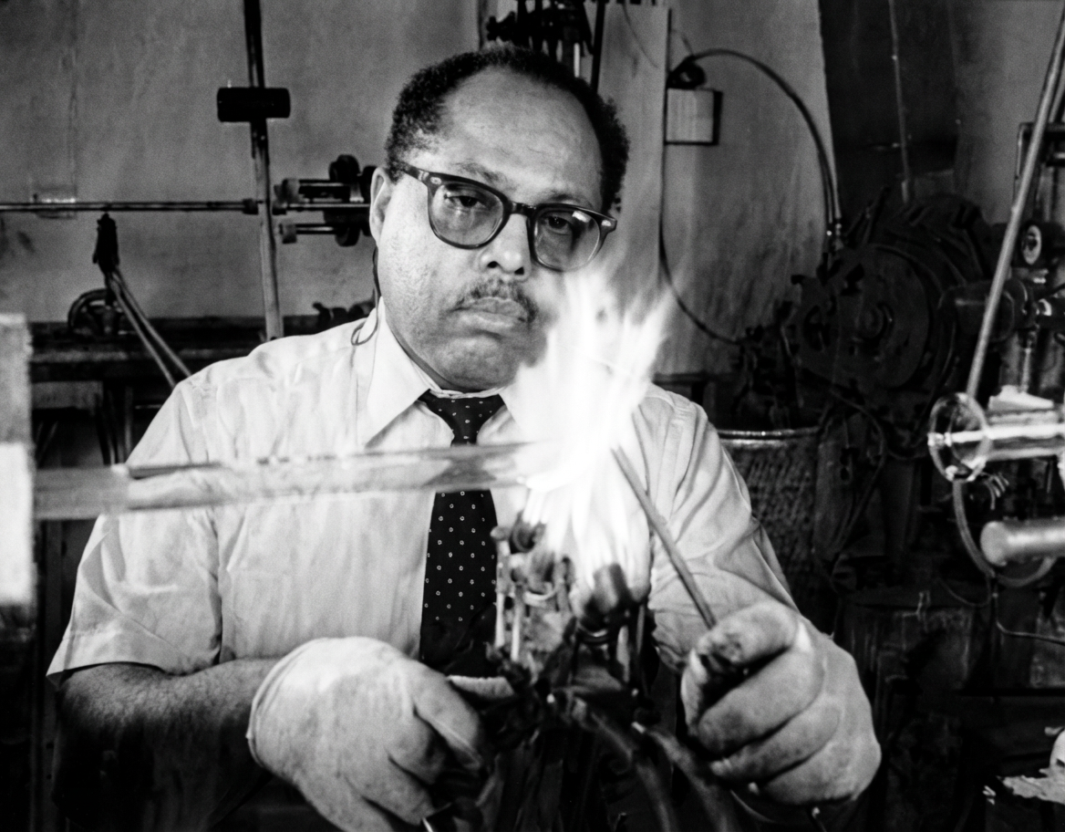 George E. Davis, founder of Vitro Technology, Ltd., working with glass in his workshop