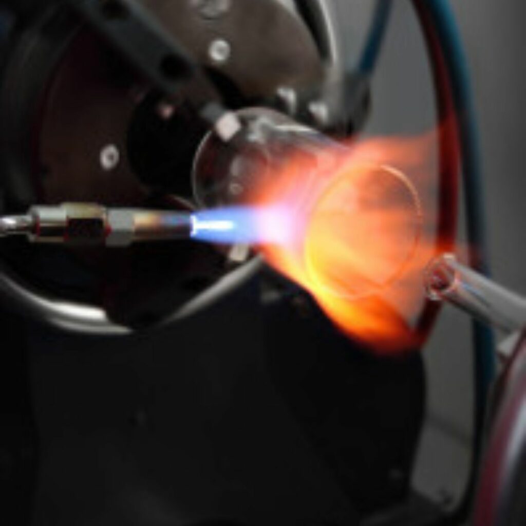 Expert glassblower shaping scientific glassware on a lathe, highlighting precision craftsmanship